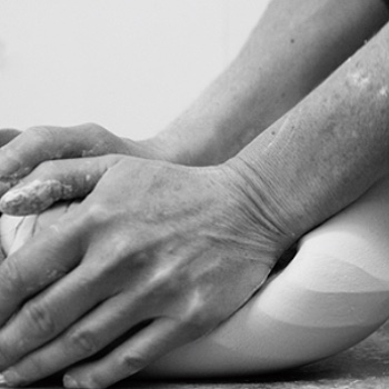 two hands holding the porcelain clay and kneading it in preparation